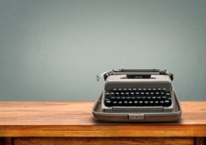 Old retro Typewriter on table with vintage gray gradient background
